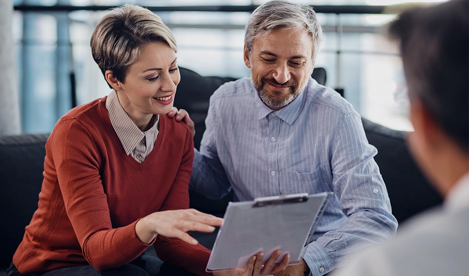 A couple who is looking at an iPad to choose a travel insurance.